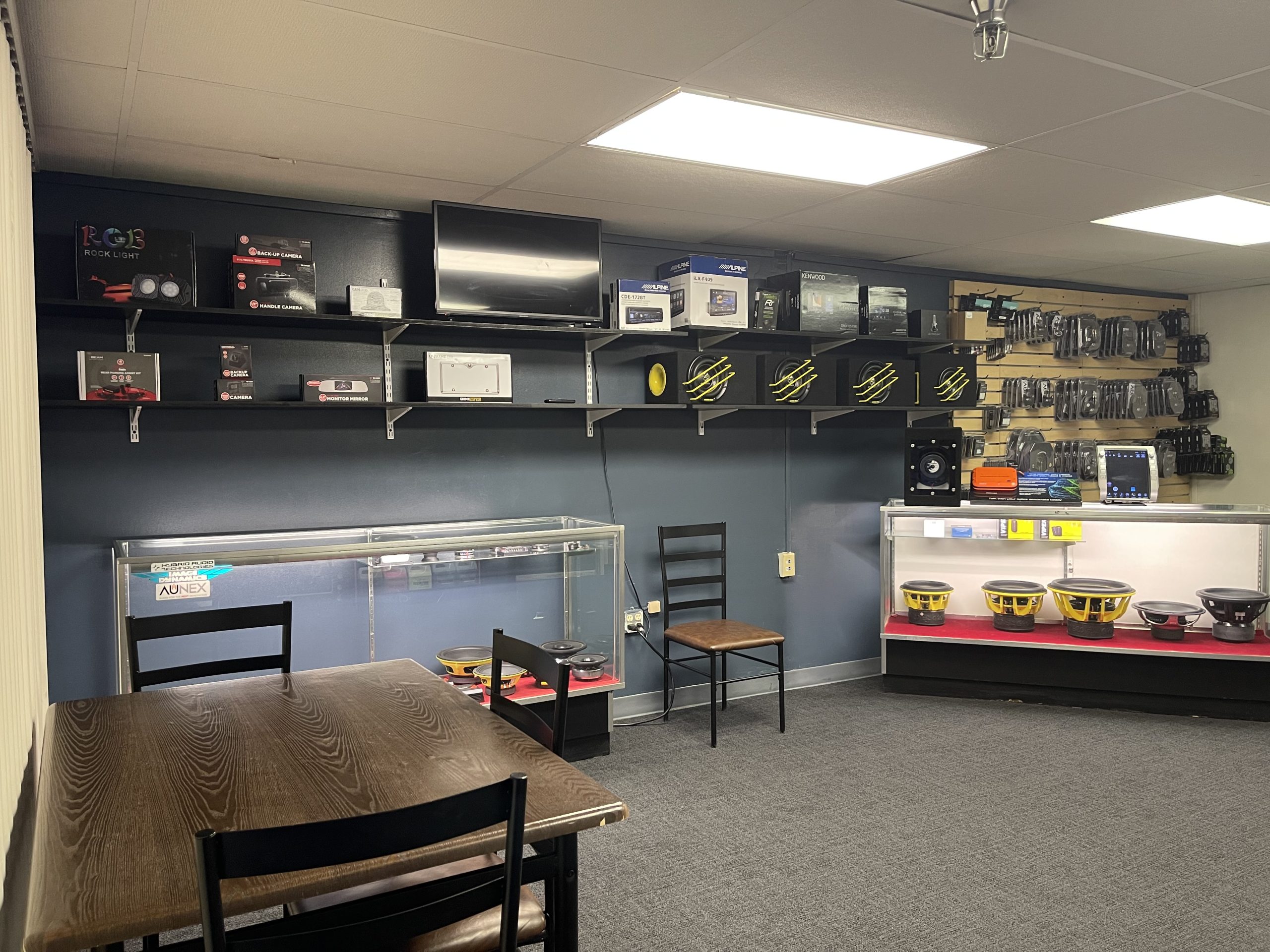 A cozy room featuring a table, chairs, and shelves, showcasing the inviting atmosphere of the Puresounds store.