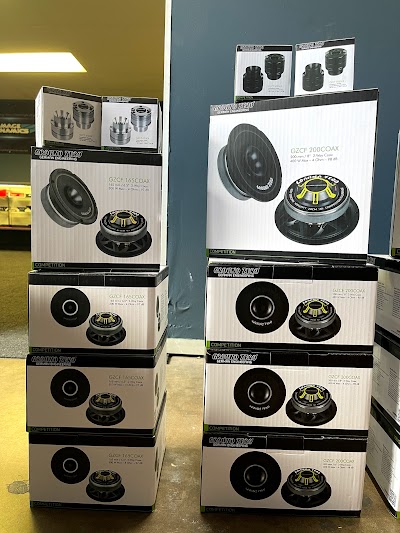 A stack of boxes containing speakers, displayed prominently at the Puresounds store, showcasing audio equipment for sale.