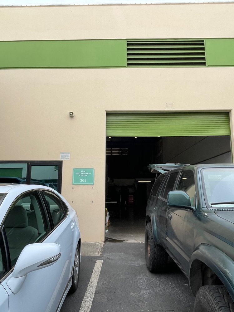 wo cars parked outside the Puresounds store, featuring a distinctive green door in the background.